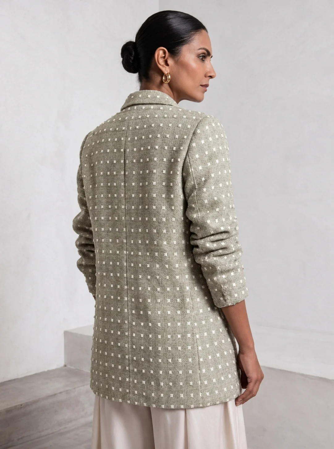 Back view of light sage green Ping Me blazer styled with ivory trousers.