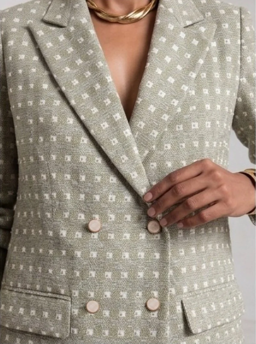 Close-up front view of light sage green Ping Me blazer showing lapels, pearl-style embellishment and double-breasted buttons.