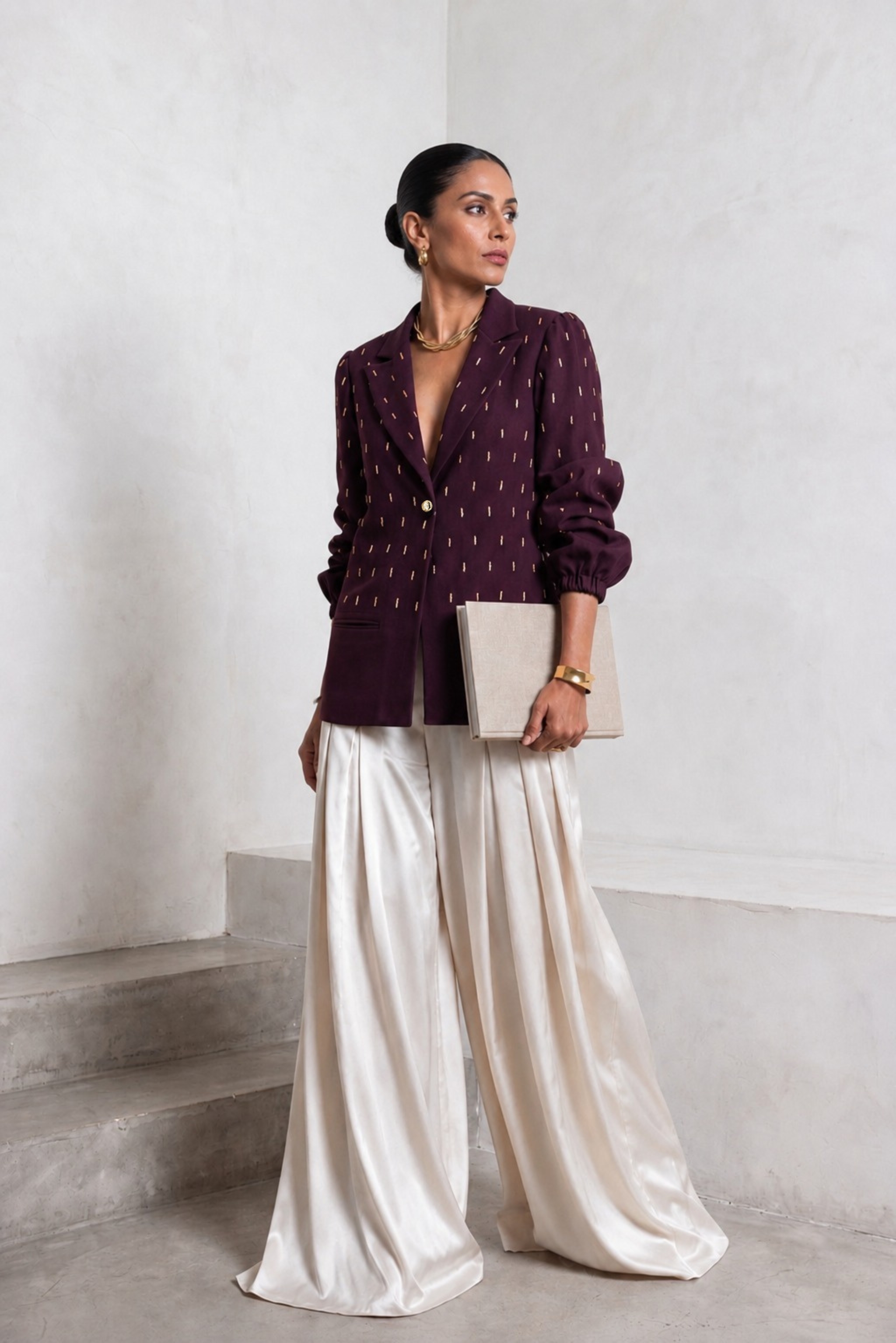 Plum embroidered blazer styled with ivory wide-leg trousers in an angled editorial view.