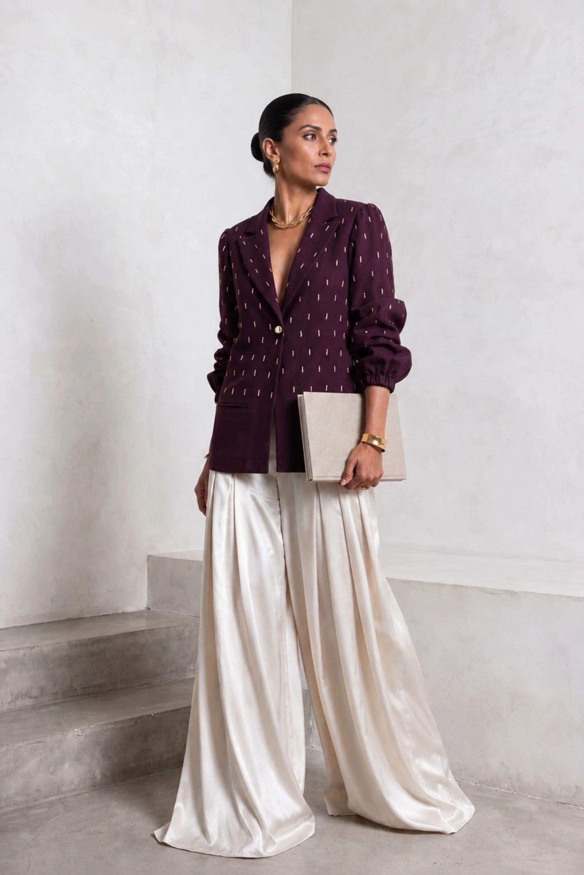 Plum embroidered blazer styled with ivory wide-leg trousers in an angled editorial view.