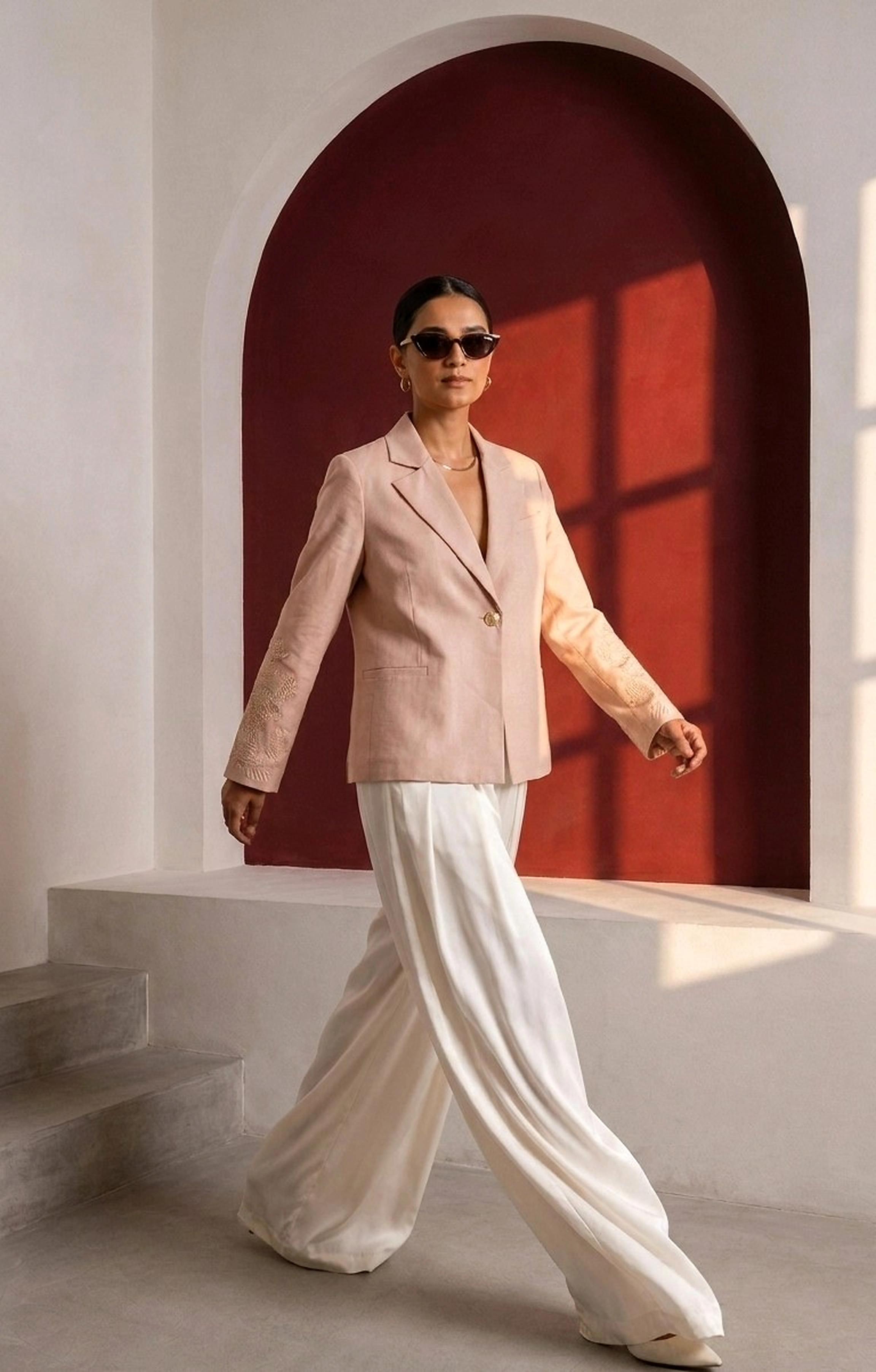Beige Brainstorm blazer with tonal embroidered sleeves styled with ivory wide-leg trousers.