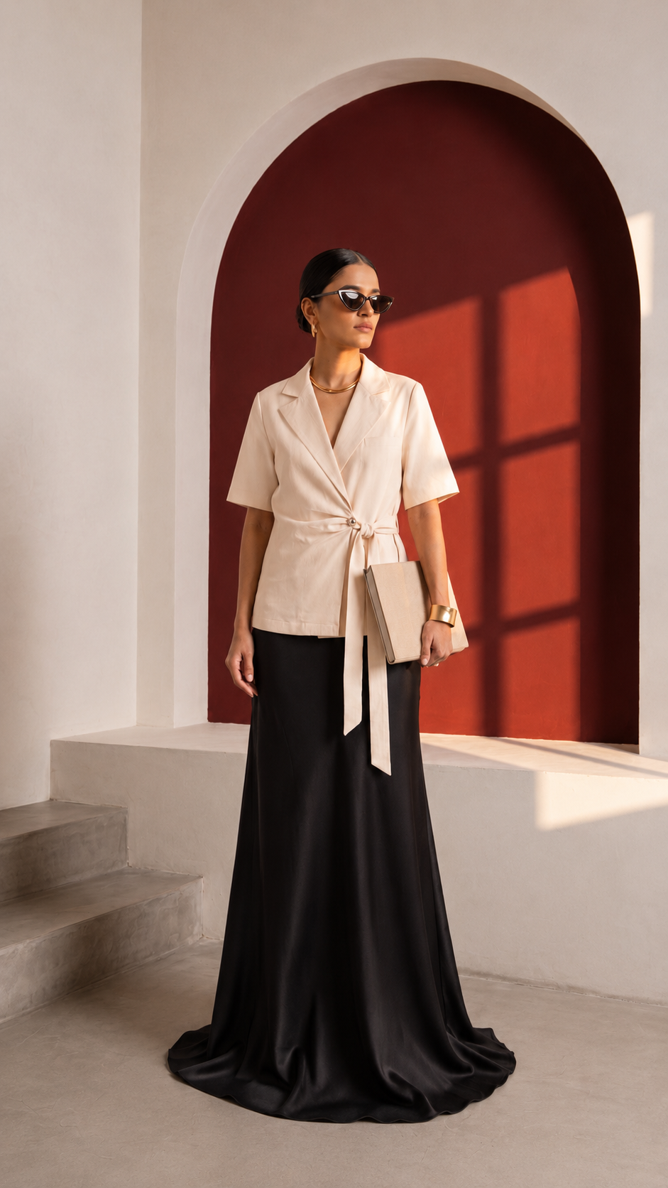 Cream Final Draft short-sleeve blazer with self-tie waist styled with a black floor-length skirt.